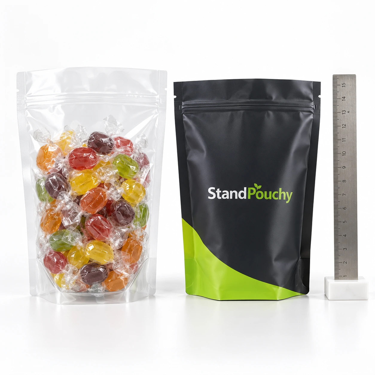 Clear conventional candy pouch with visible wrapped pieces beside charcoal StandPouchy pouch and ruler